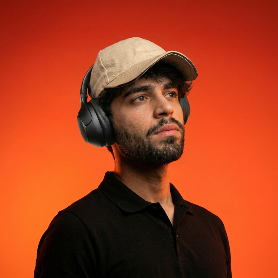Sayed Hamza wearing headphones in an orange studio